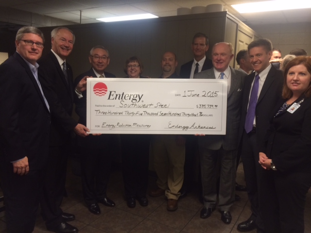 The check presentation was attended by (left to right) –Chris Murphy, Entergy Arkansas Business Development, Governor Asa Hutchinson, Tad Inami, President Arkansas Steel, Paula Sigman, Plant Manager Southwest Steel Processing, Daniel Baker, Maintenance Engineer Southwest Steel Processing, Ken Copeland, President Southwest Steel Processing, Edward Crawford, CEO Park-Ohio Holdings, Chris Direnzi, Capacity Energy Solutions, and Jennifer Diaz, CLEAResult.